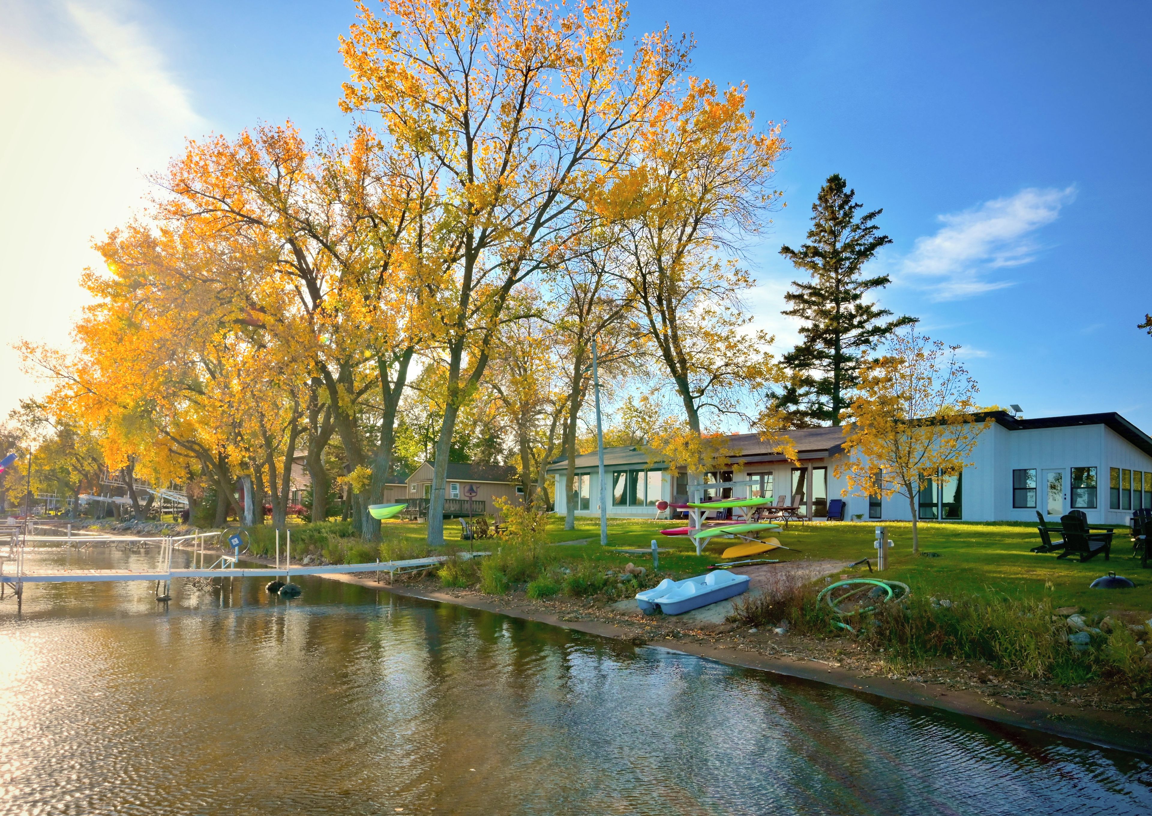 A residential area with a pond, houses, and a dock.