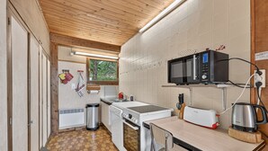Een kleine keuken met een magnetron, broodrooster en spoelbak.