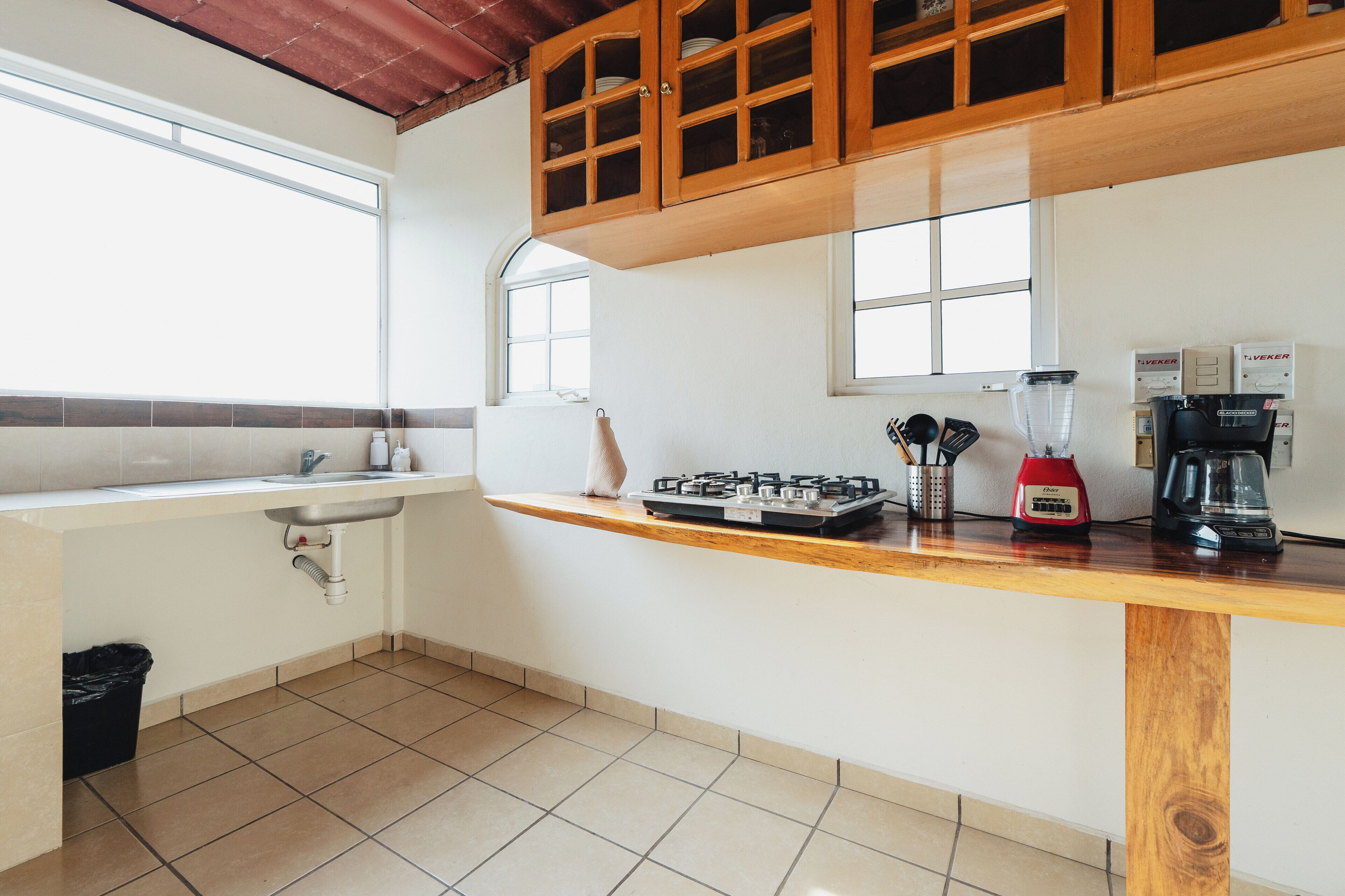 Una cocina con lavamanos, estufa y cafetera.