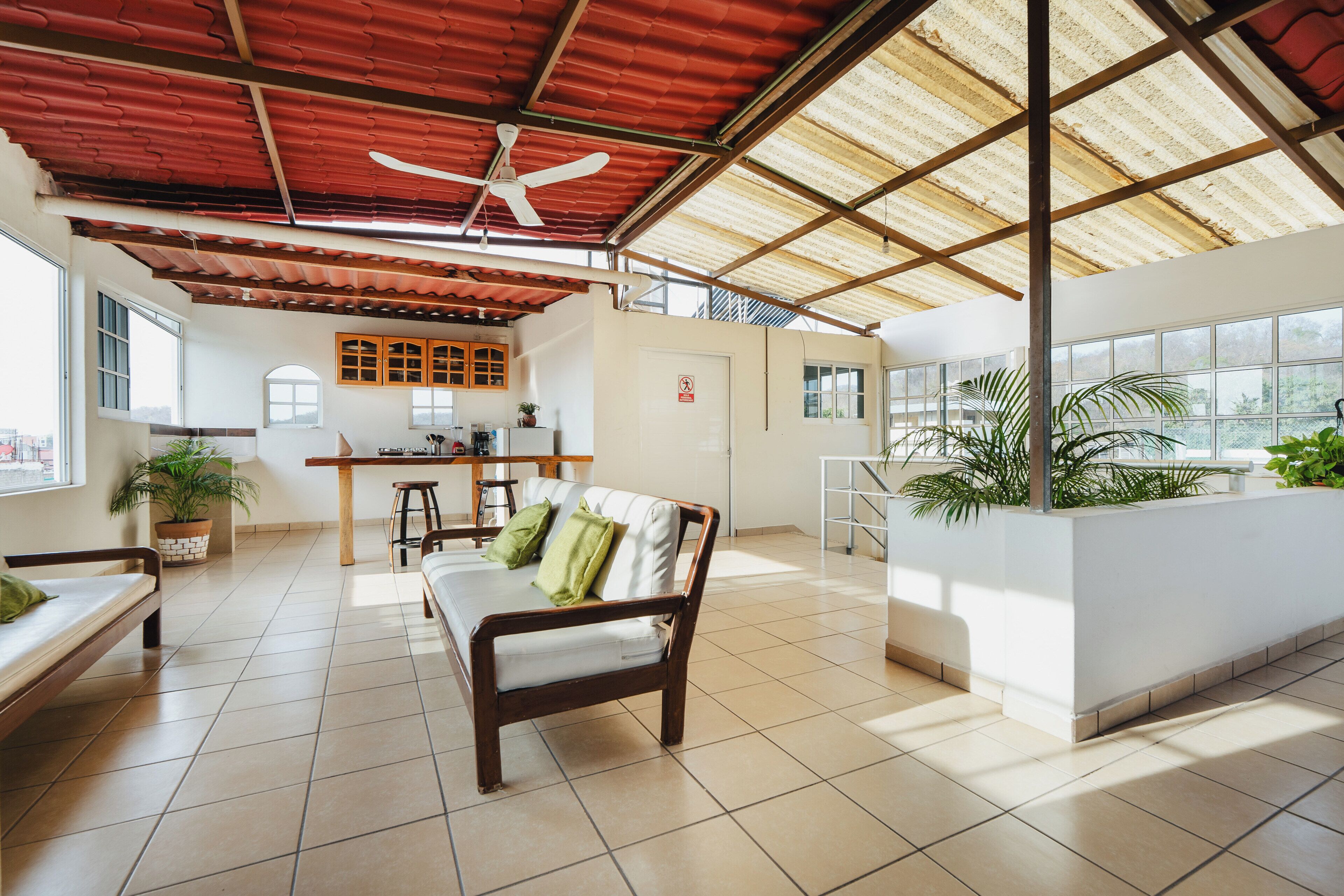 Amplia sala de estar con sofá, mesa de comedor y cocina al fondo.