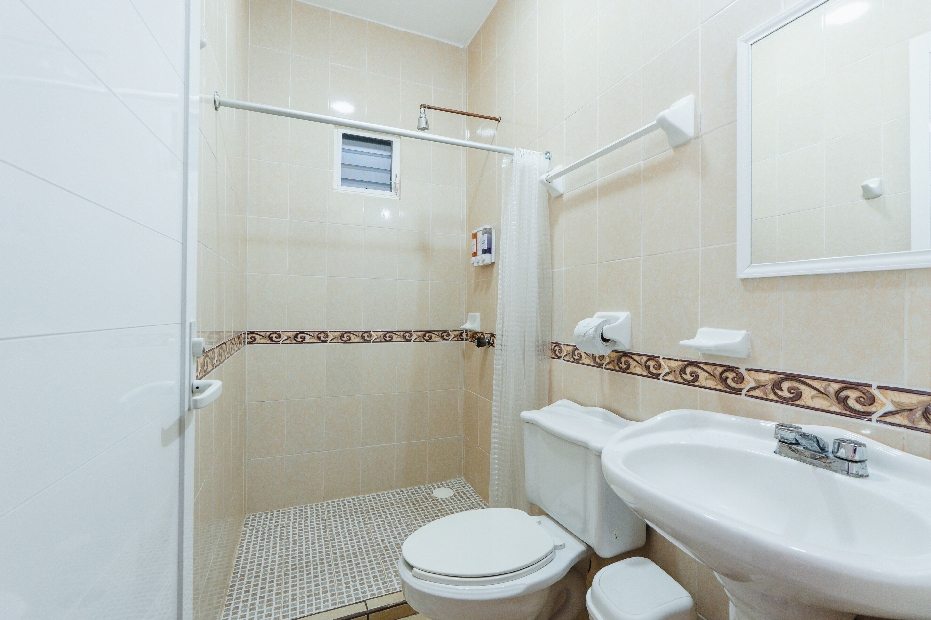 A bathroom with a shower, toilet, and sink.