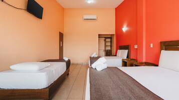 Une chambre d’hôtel avec deux lits simples, un téléviseur fixé au mur et un appareil de climatisation.