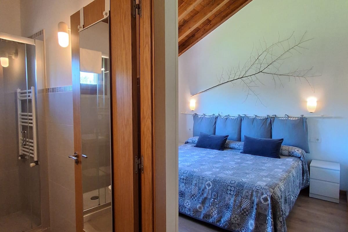 A bedroom with a bed, bedside table, and a nightstand.
