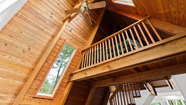 A wooden interior with a ceiling fan, skylights, and a wooden staircase. - Coastal Woodlands A-Frame Sanctuary with Hot Tub (Heceta Beach)