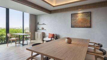 Un comedor moderno con una mesa de madera, sillas y vistas a zonas verdes.