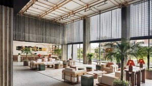 A spacious lobby with high ceilings, large windows, and a variety of seating arrangements. - NHAAN Resort & Spa Hoi An, Tapestry Collection by Hilton (Hoi An)