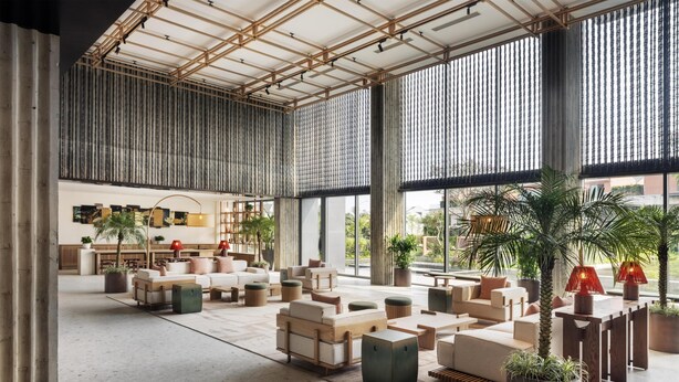 A spacious lobby with high ceilings, large windows, and a variety of seating arrangements. - NHAAN Resort & Spa Hoi An, Tapestry Collection by Hilton (Hoi An)