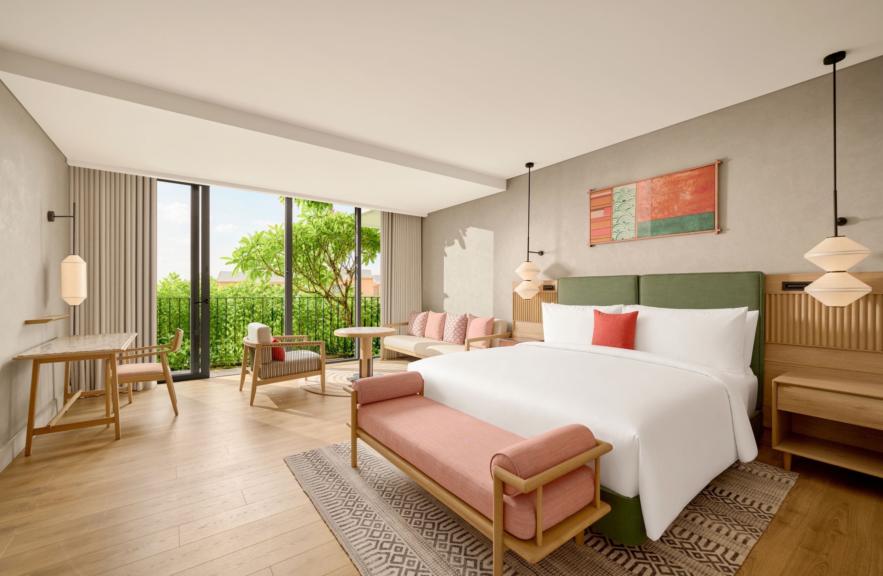 Quarto de hotel moderno com uma cama grande, um espaço de estar com um banco, uma mesa de trabalho e vista para o verde lá fora.