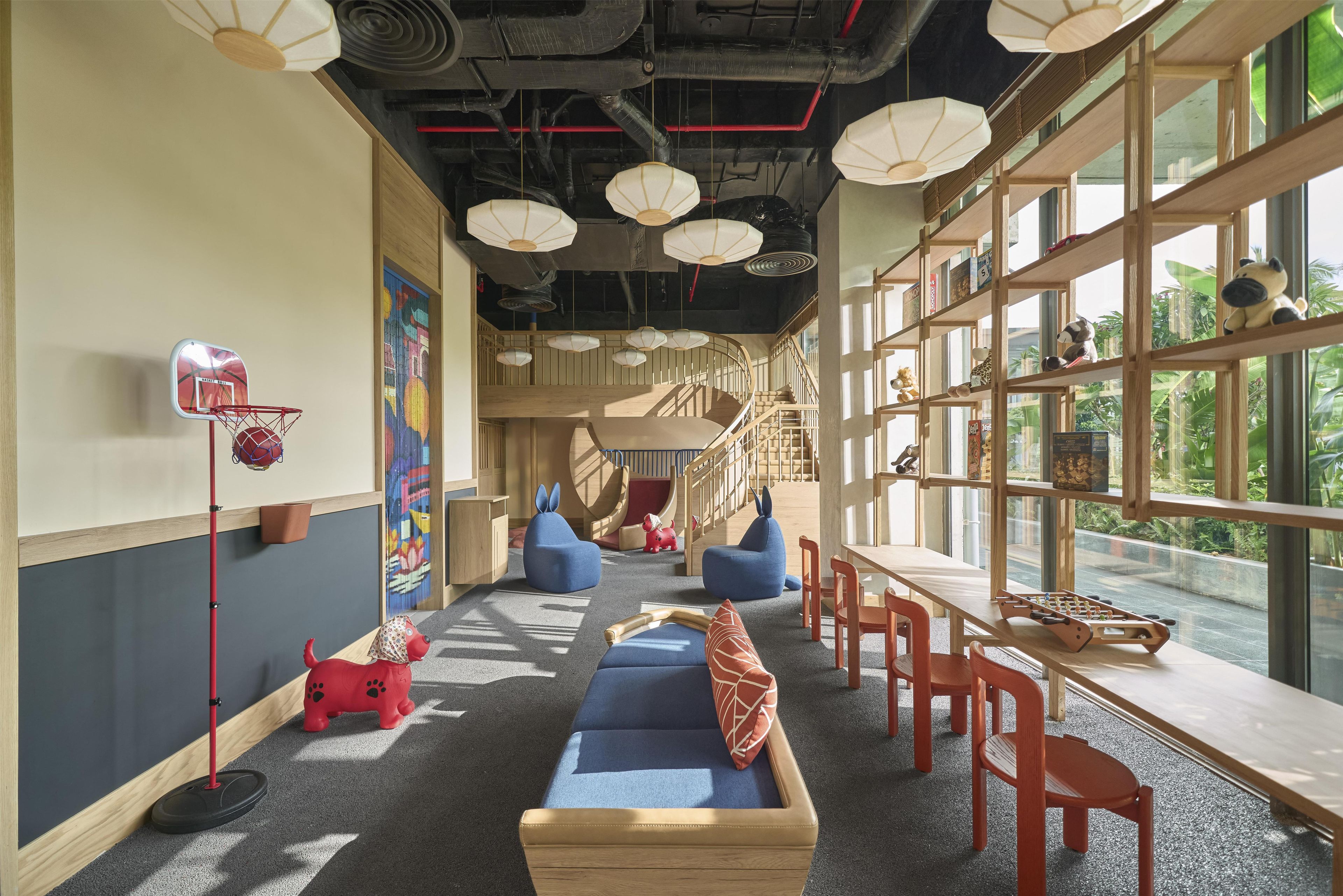 A modern interior with a central staircase, seating areas, and a view through large windows.