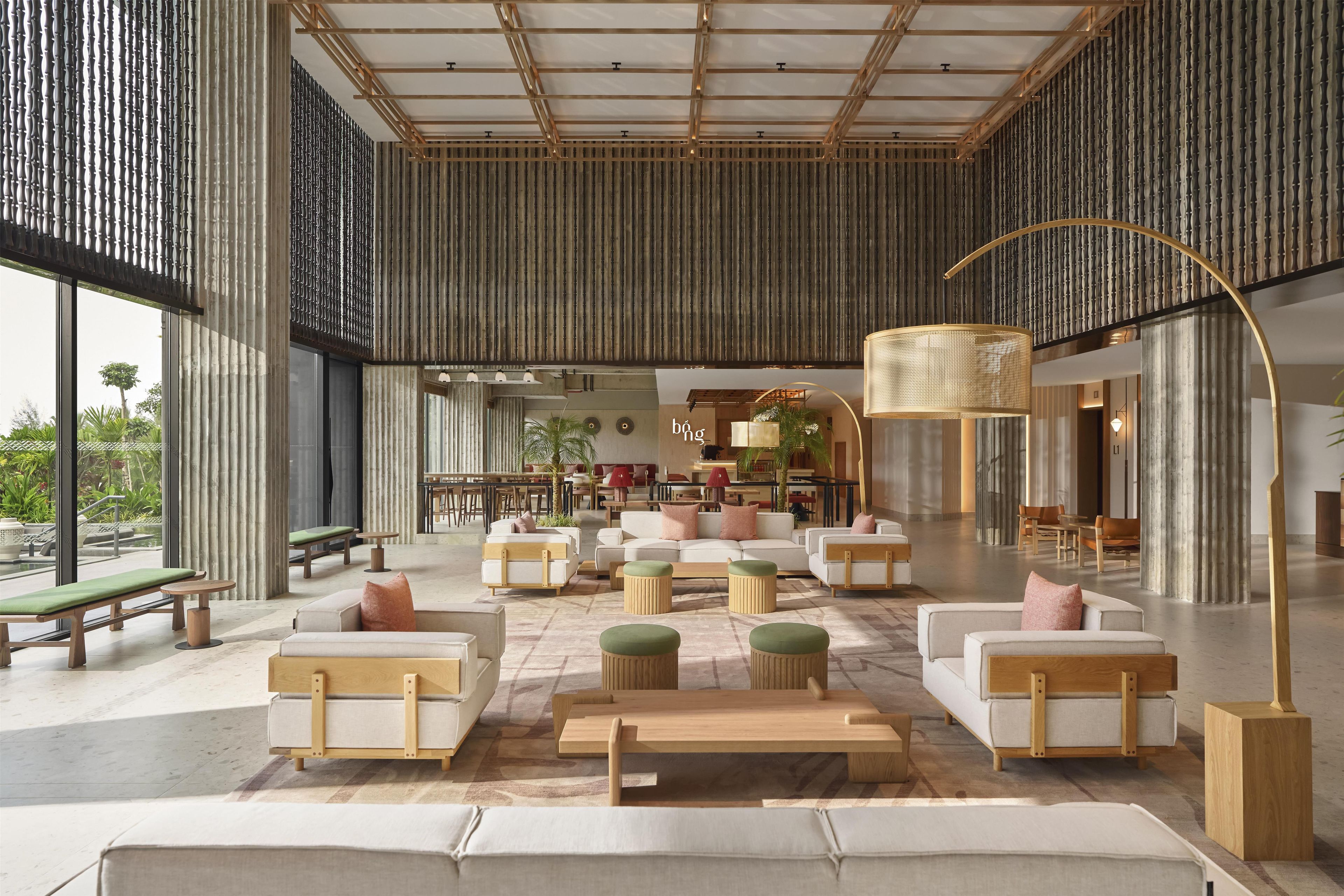A spacious lobby with high ceilings, modern furniture, and large windows.