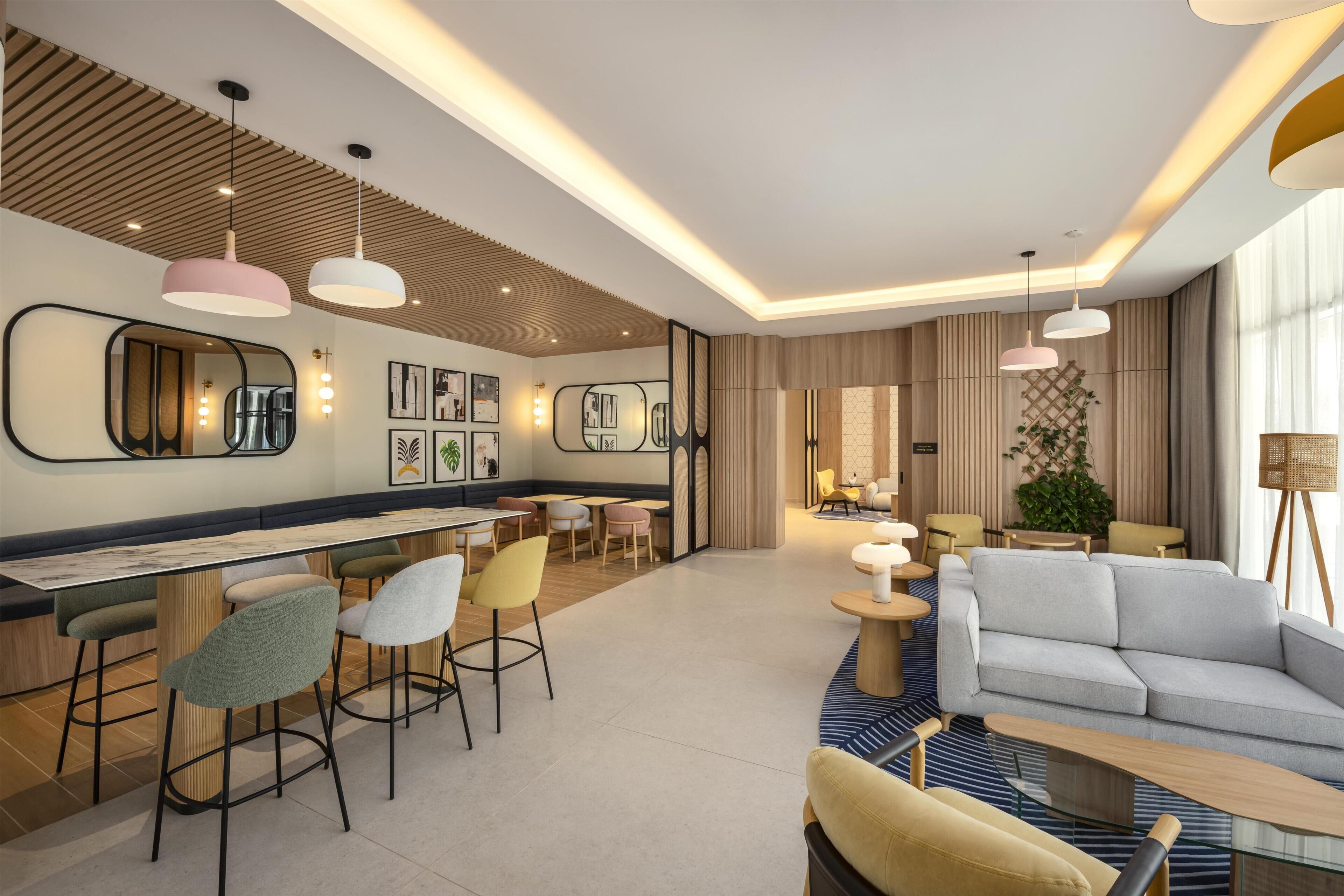 Eine moderne Hotelhalle mit Barbereich, Sitzgelegenheiten und einer Couch.