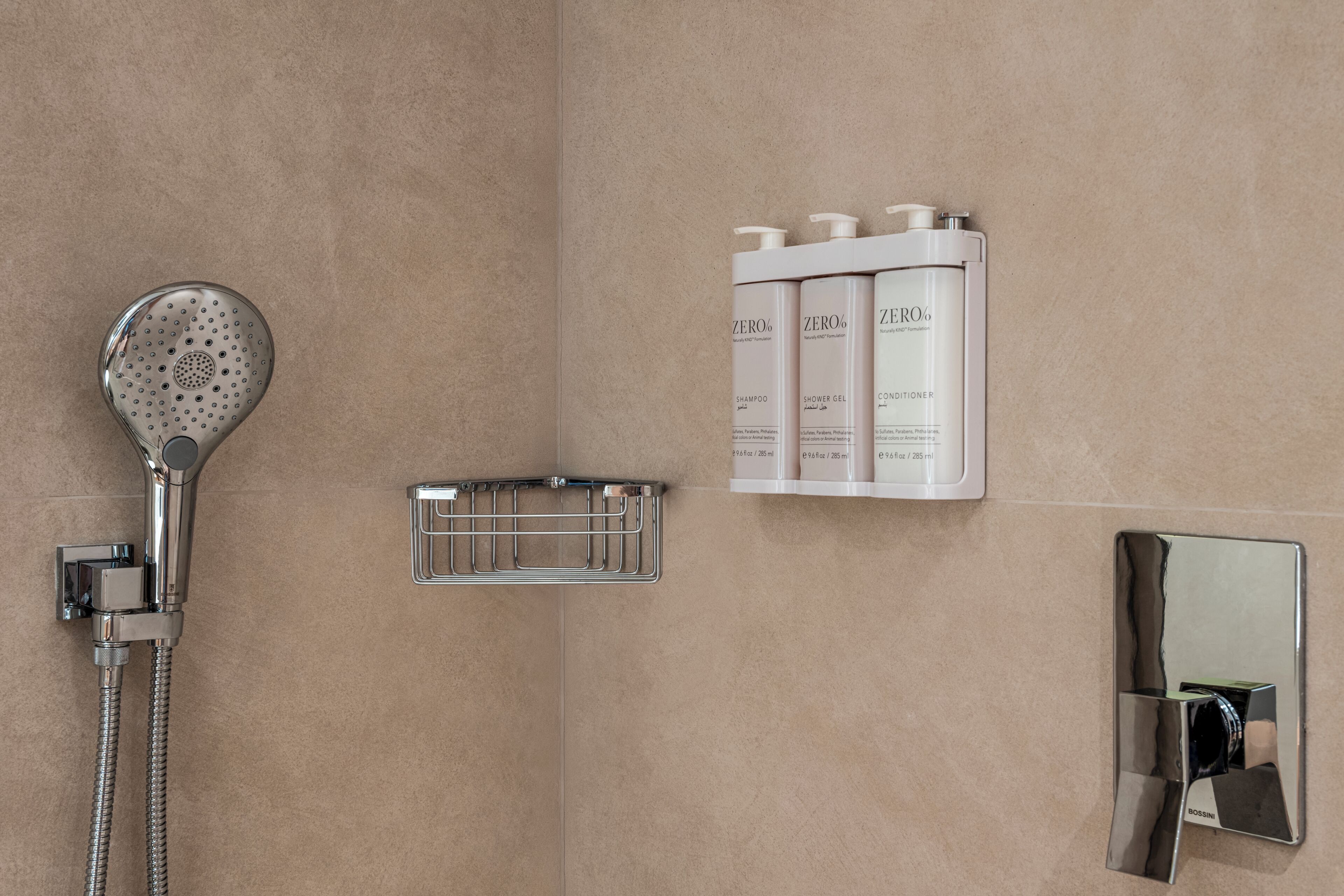 Ein Badezimmer mit Dusche, einem Handtrockner und einem Satz Toilettenartikeln.