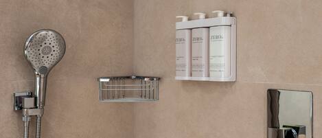 Ein Badezimmer mit Dusche, einem Handtrockner und einem Satz Toilettenartikeln.