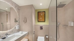 A modern bathroom with a large mirror, a shower, a toilet, and a sink. - Hampton By Hilton Jeddah Souq7 (Jeddah)