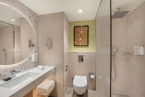 A modern bathroom with a large mirror, a shower, a toilet, and a sink. - Hampton By Hilton Jeddah Souq7 (Jeddah)