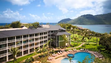 A resort with a swimming pool, multiple balconies, and a view of the ocean.