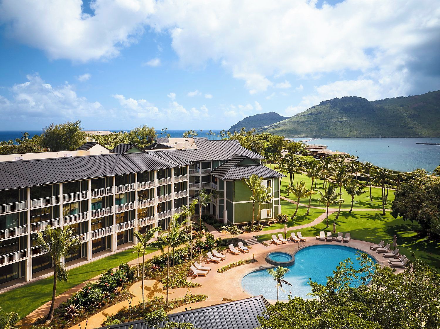 A resort with a swimming pool, multiple balconies, and a view of the ocean.