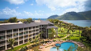 A resort with a swimming pool, multiple balconies, and a view of the ocean.