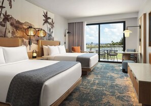 Een hotelkamer met twee bedden, een balkon en een eethoek met uitzicht.