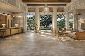 A spacious lobby with a reception desk, seating area, and large windows offering a view of greenery. - Hale Hokuala Kauai, Curio Collection By Hilton (Lihue)