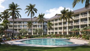A hotel with a pool, palm trees, and multiple balconies. - Hale Hokuala Kauai, Curio Collection By Hilton (Lihue)