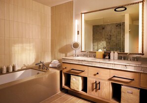 Een moderne badkamer met een bad, wastafel en een grote spiegel.