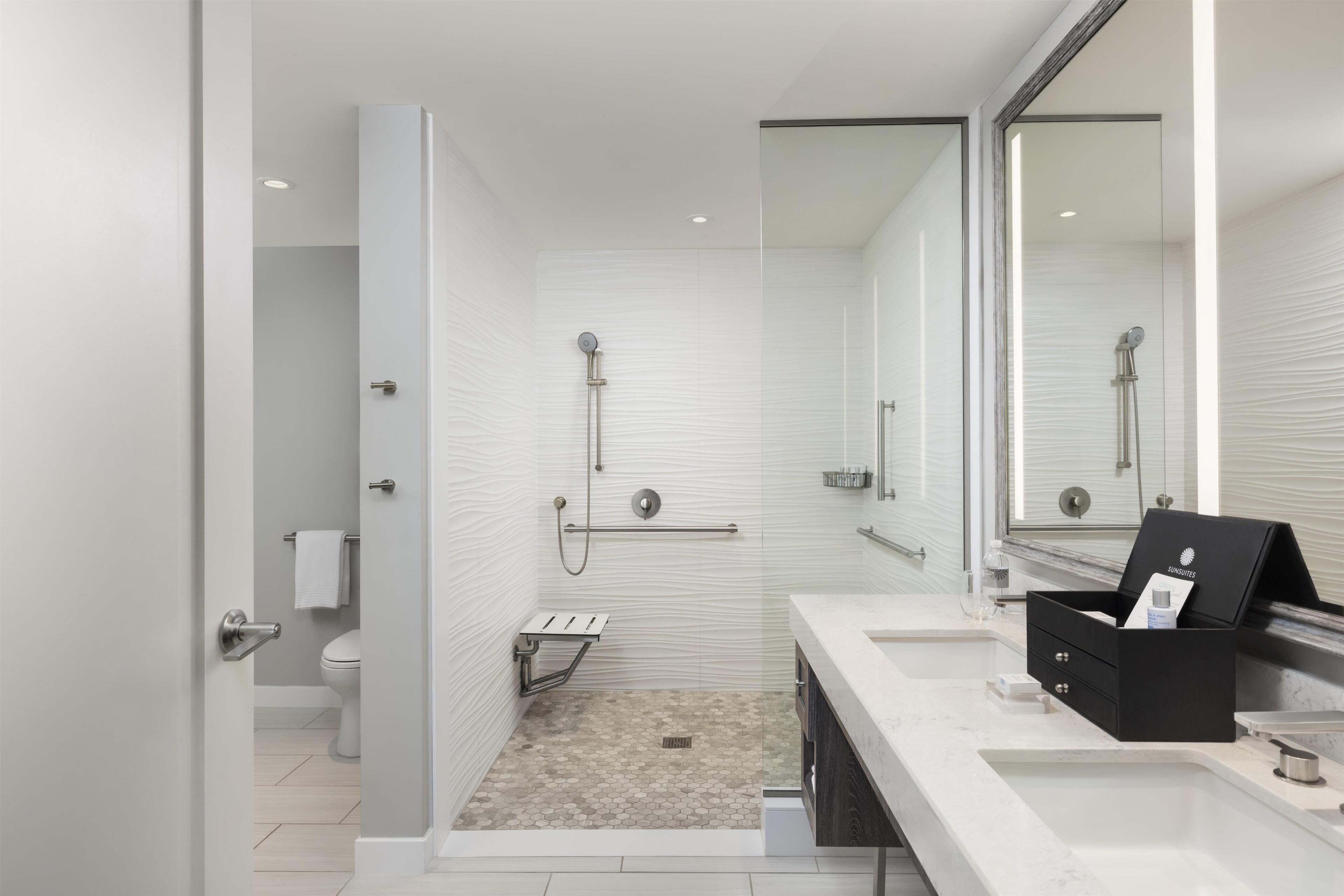 A modern bathroom with a shower, toilet, and vanity.