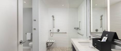 A modern bathroom with a shower, toilet, and vanity.