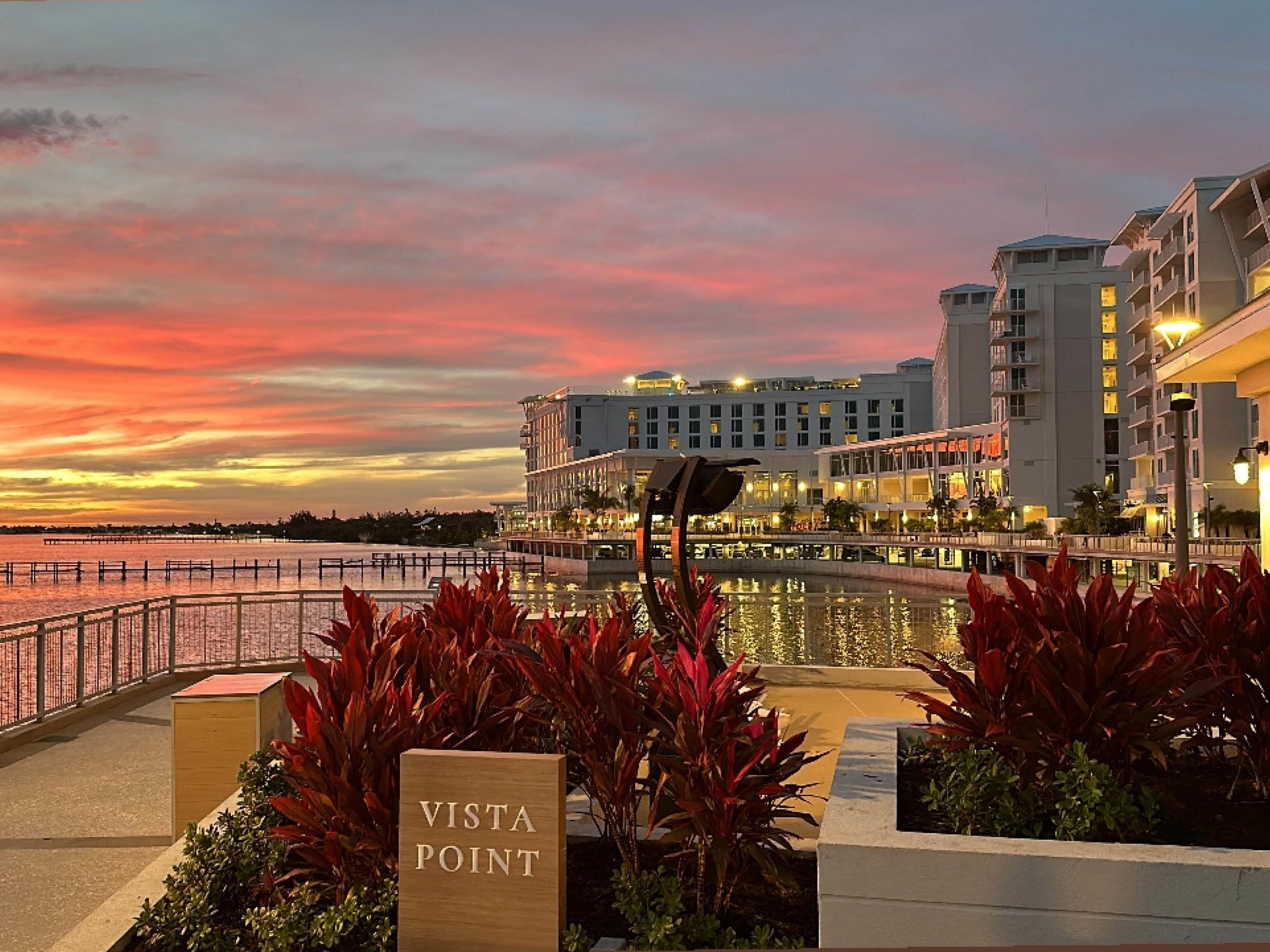 A waterfront hotel with a sign reading 'VISTA POINT,' featuring a modern architectural style with multiple floors and balconies.
