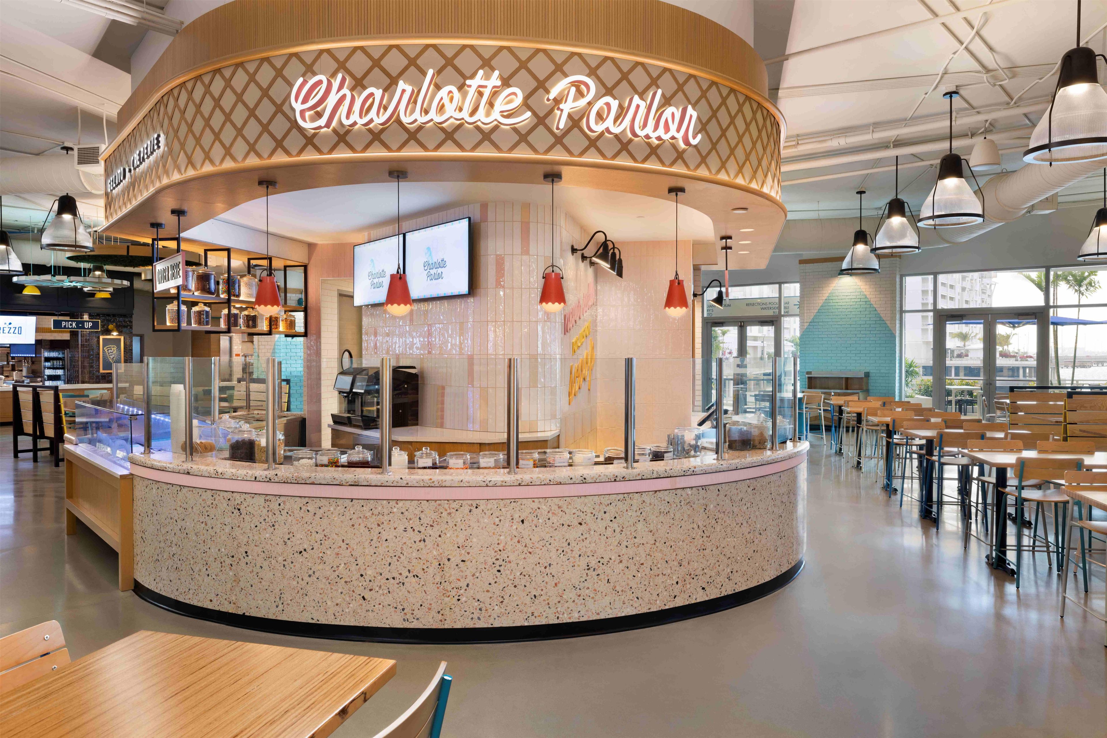Un salón Charlotte con mostrador circular, vitrinas de cristal e iluminación colgante.
