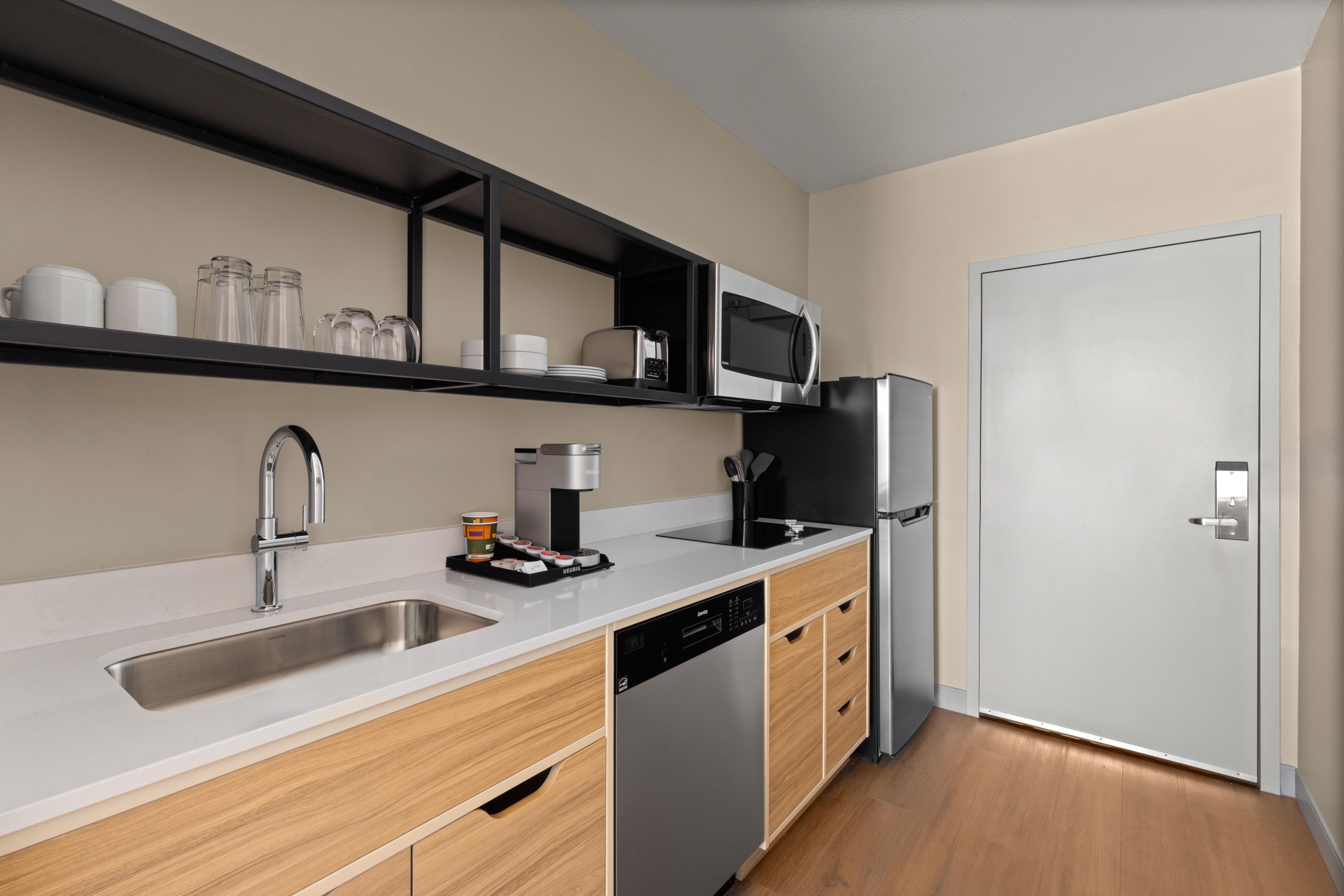 A modern kitchen with a stainless steel sink, a coffee machine, and a microwave.
