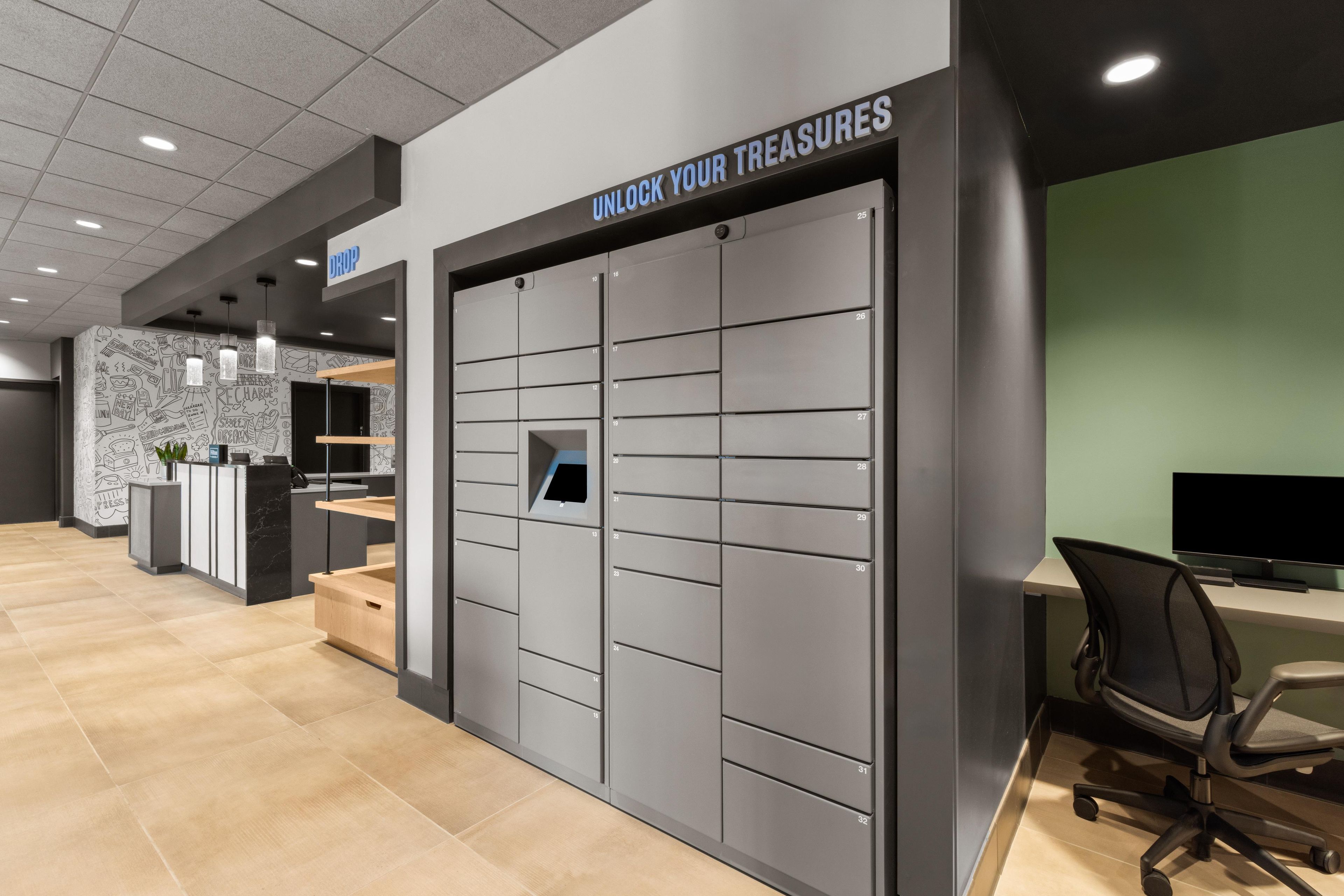 A modern office space with a grey filing cabinet labeled 'UNLOCK YOUR TREASURES' and a reception desk with a 'DROP' sign.