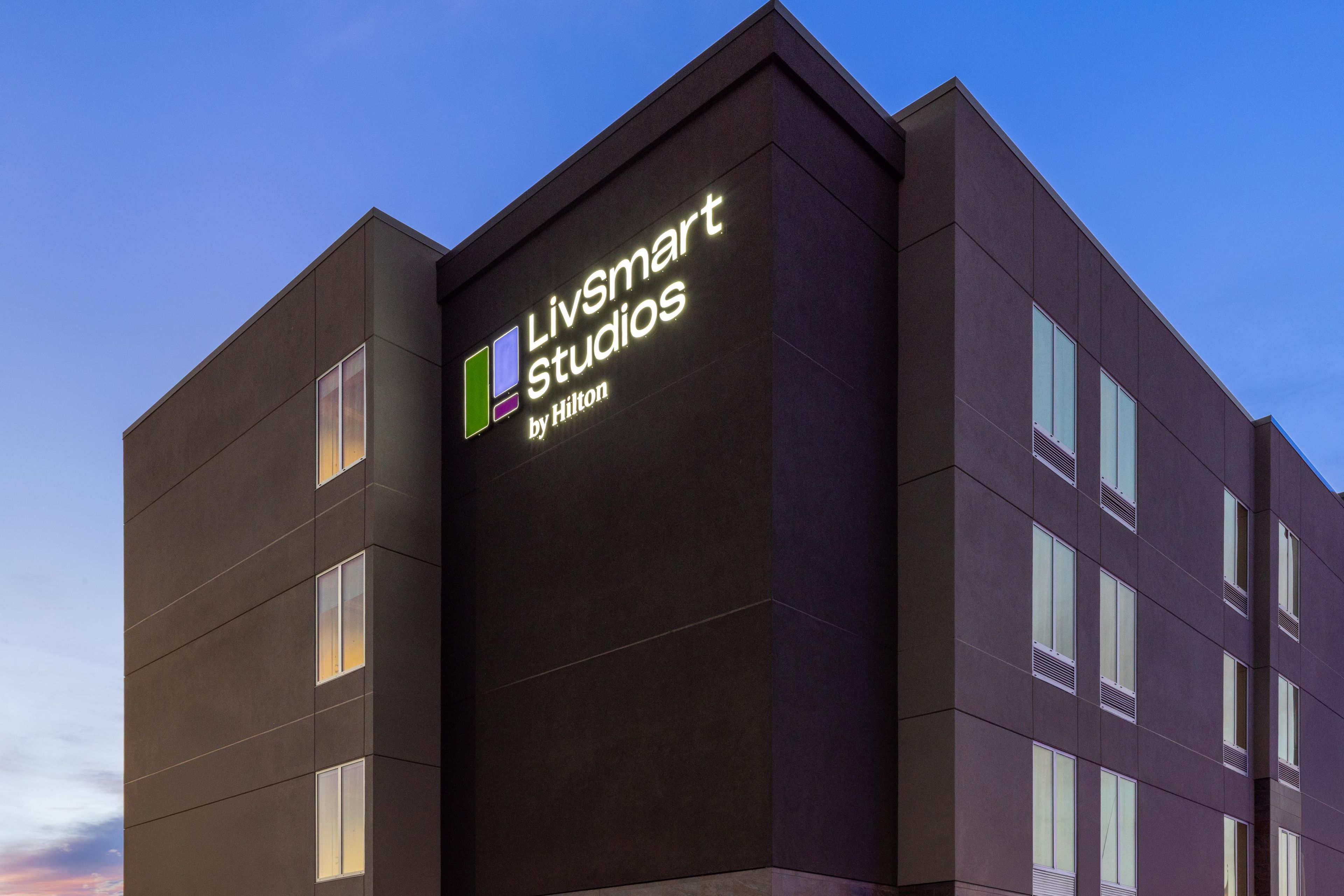 Ein modernes Gebäude mit einem Schild für 'Livsmart Studios by Hilton'.