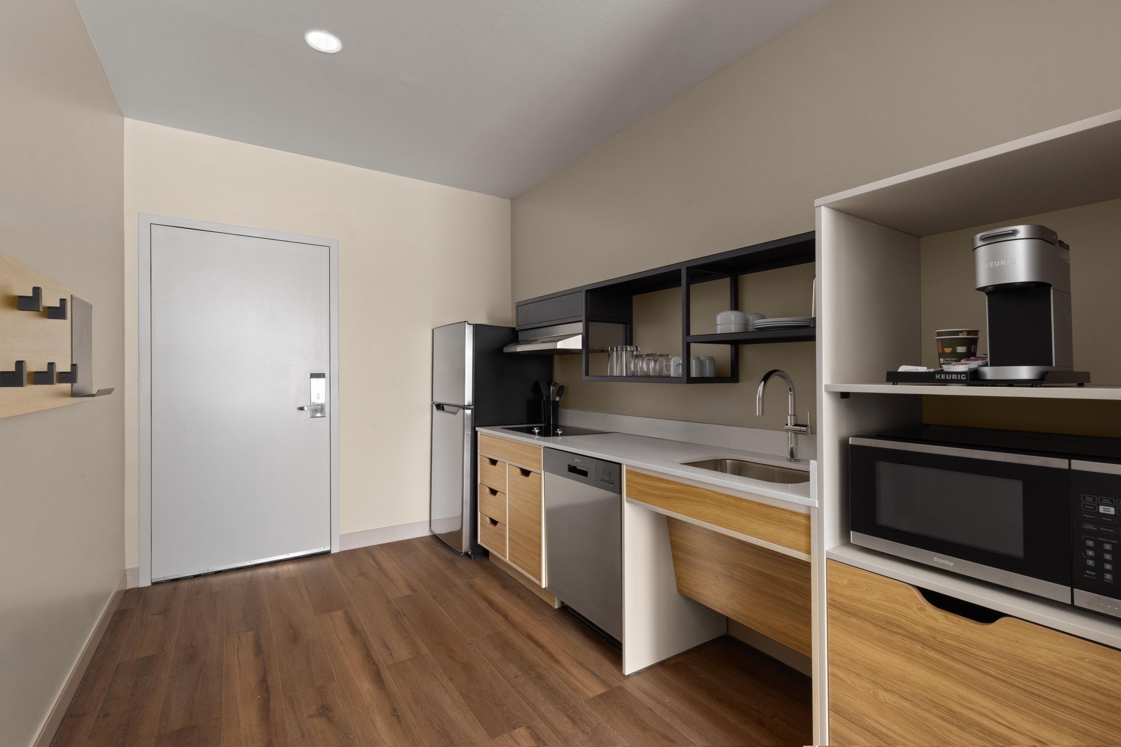 A modern kitchen with a built-in dishwasher, a microwave, and a coffee machine.