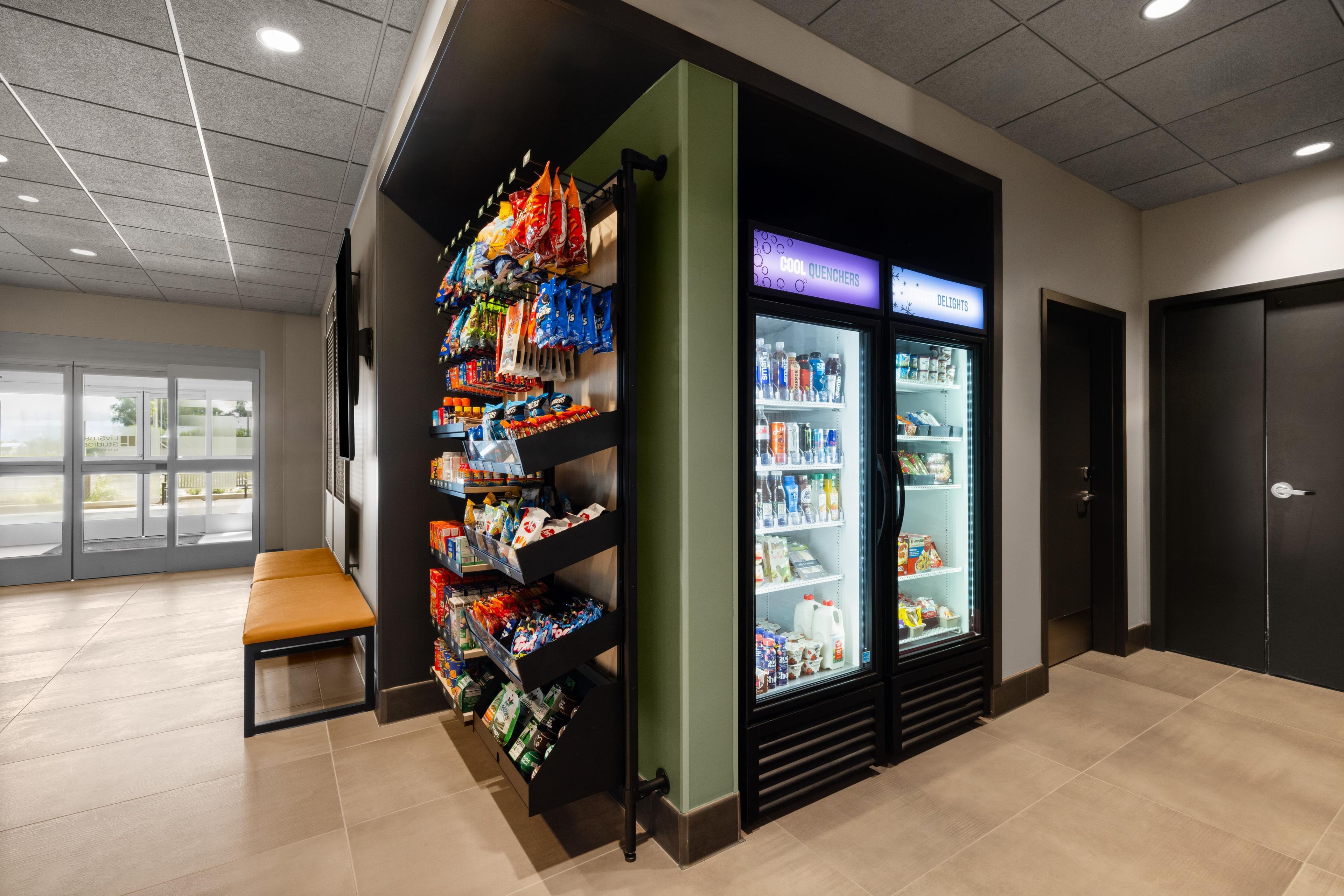 A vending area with snacks and drinks, a seating bench, and a refrigerated section labeled 'COOL QUENCHERS' and 'DELIGHTS'.