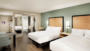 A hotel room with two beds, a desk, a chair, a small table, a bathroom, and a kitchenette. - LivSmart Studios by Hilton Salt Lake City West Valley City (West Valley City)