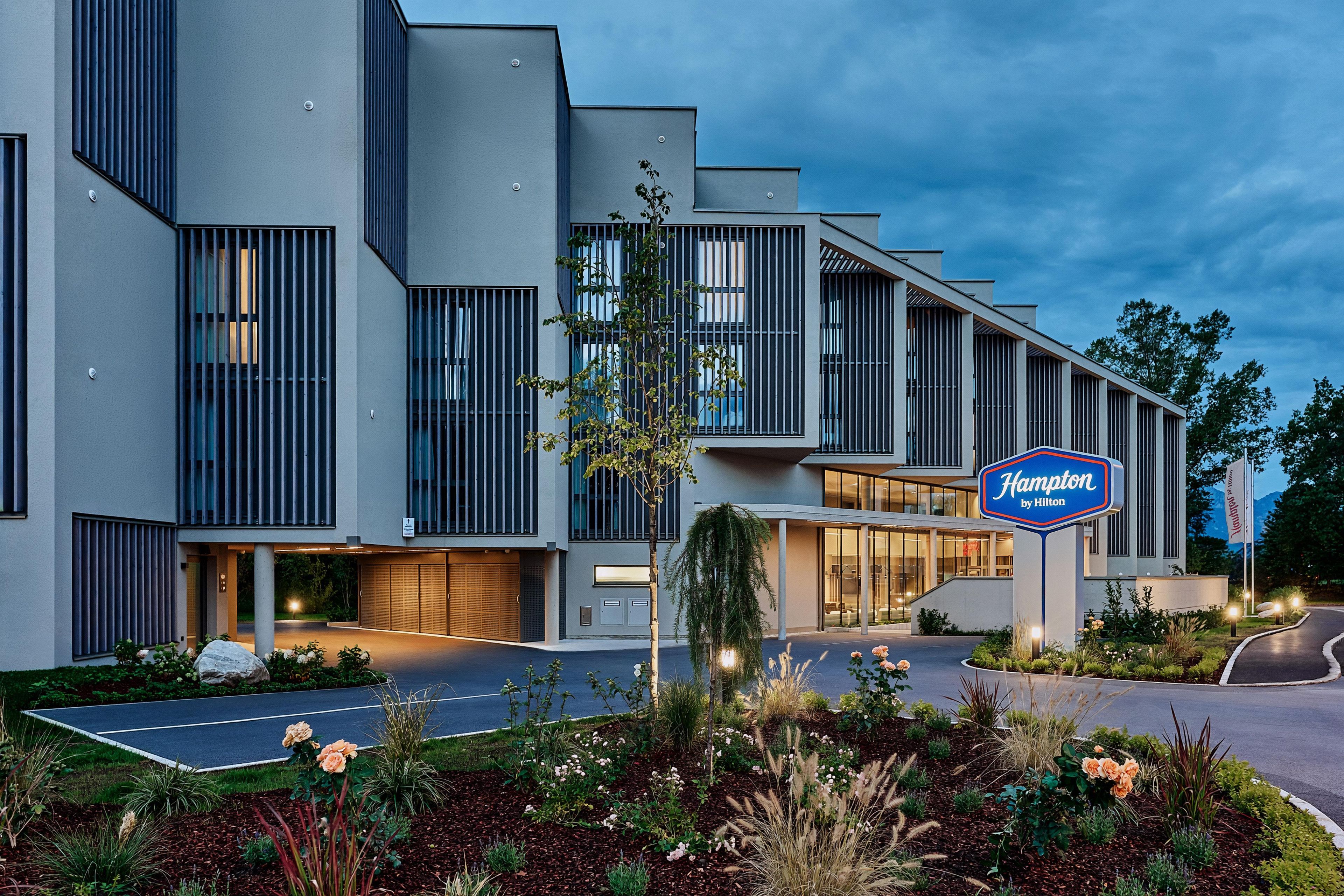 Ein modernes Hotel mit einem Schild, das es als Hampton by Hilton ausweist.
