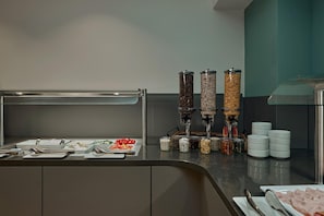 Disposición de un bufé con diferentes recipientes y utensilios para la comida.
