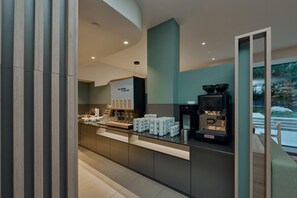 Un café moderne doté d’une machine à expresso La Cimbali, de tasses à café disposées avec soin et d’un tableau affichant le menu.