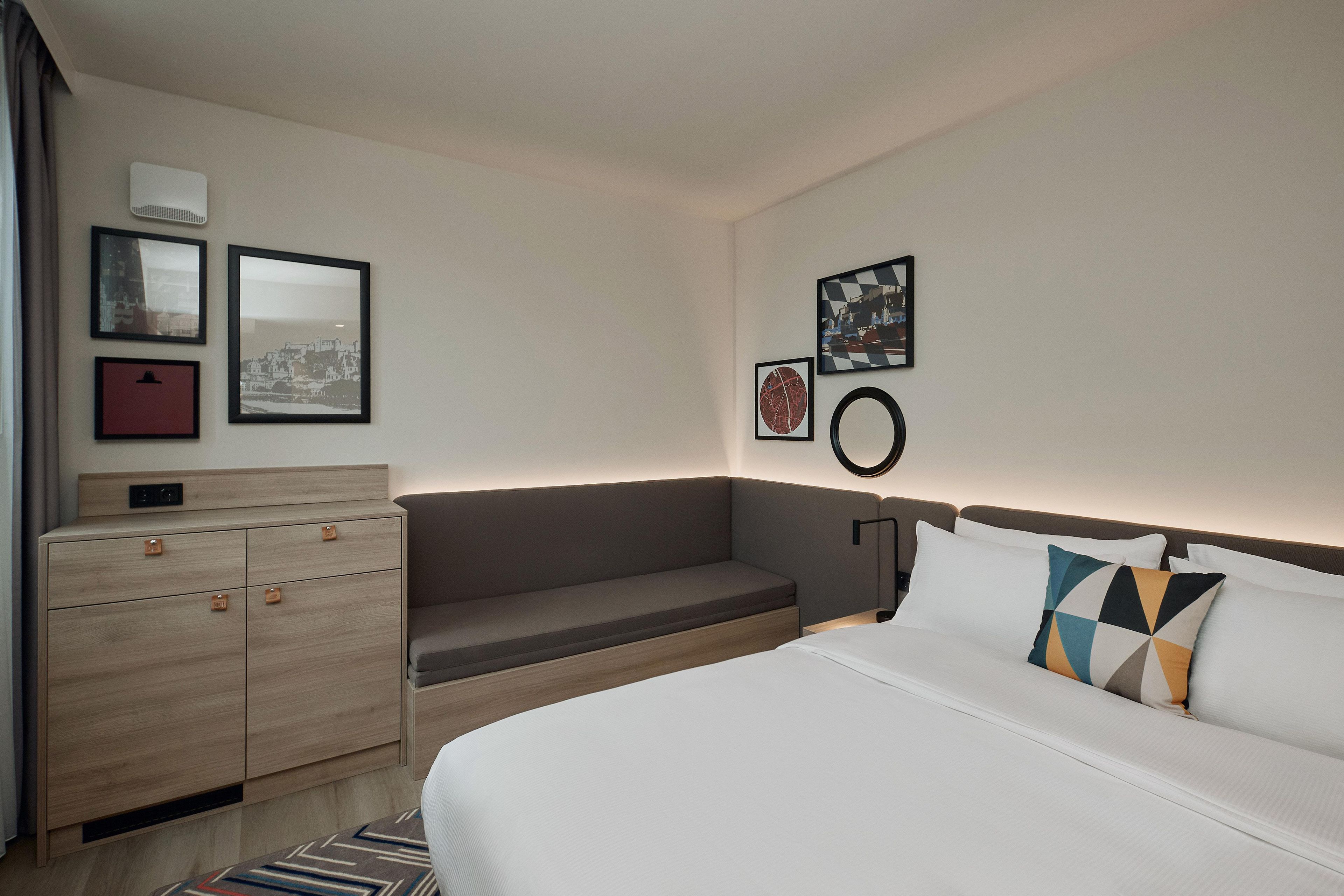 Habitación de hotel con cama, cómoda y zona de estar.
