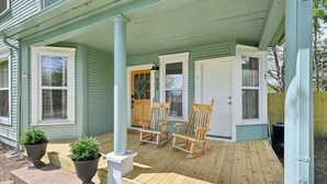 A porch with a wooden bench, two potted plants, and a door with the number 408. - The 408 Family Farmhouse (Siloam Springs)