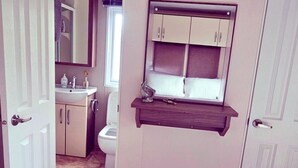 Un baño con inodoro, lavamanos y armarios.