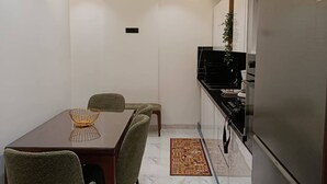 A compact kitchen with a dining area, a refrigerator, and a small island with a sink. - Charming 2-bedroom Apartment in Tunis With City Views (La Marsa)