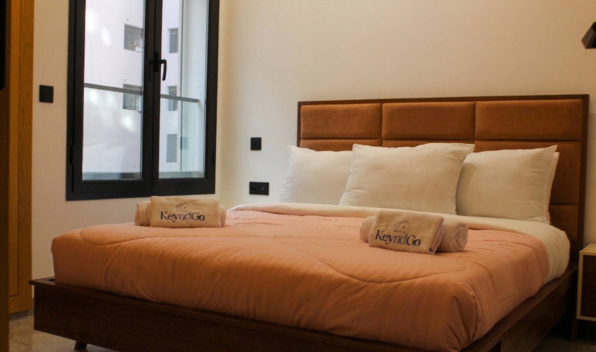 Een bed met hoofdbord, twee kussens en een dekbed.