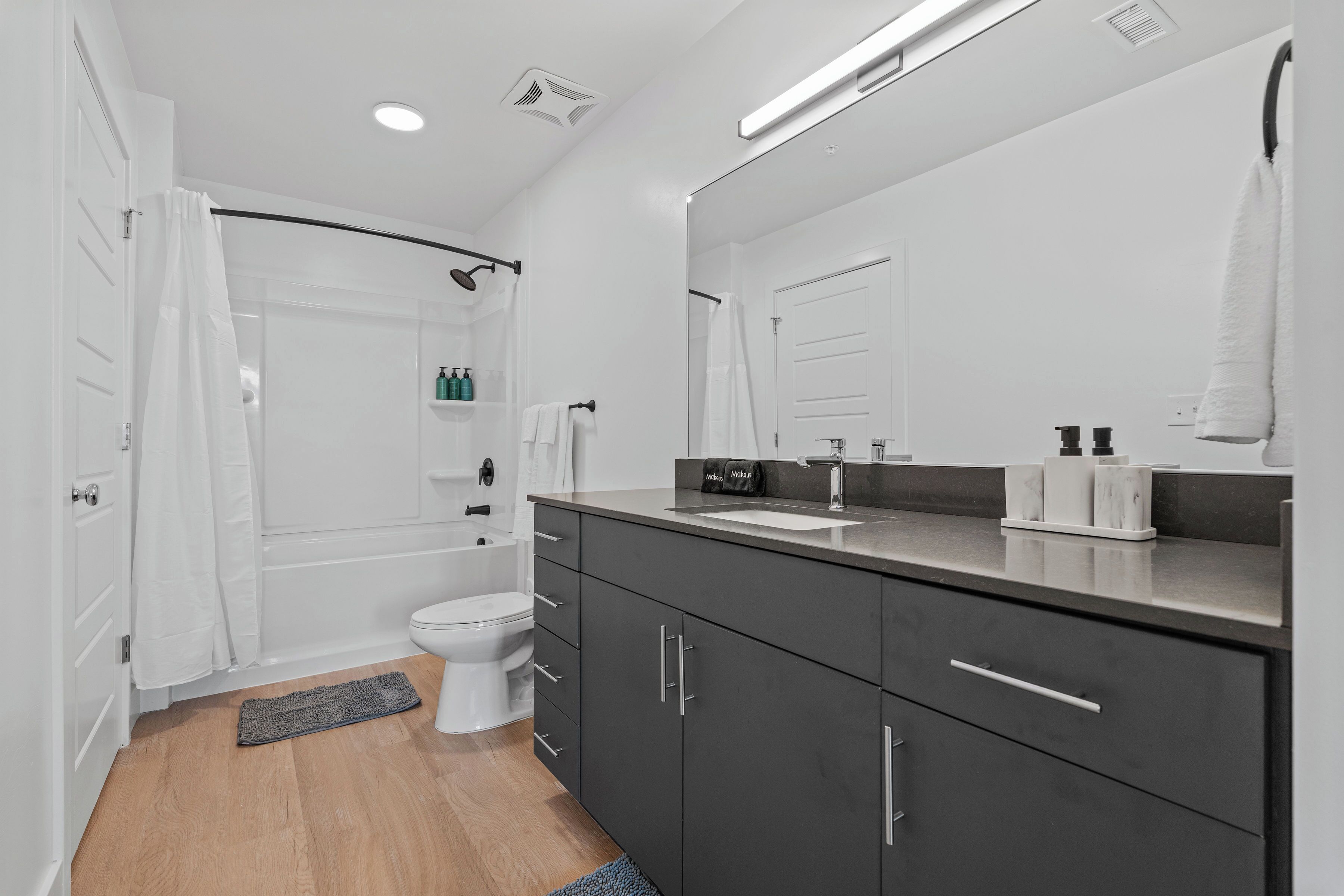A modern bathroom with a shower, toilet, and vanity.