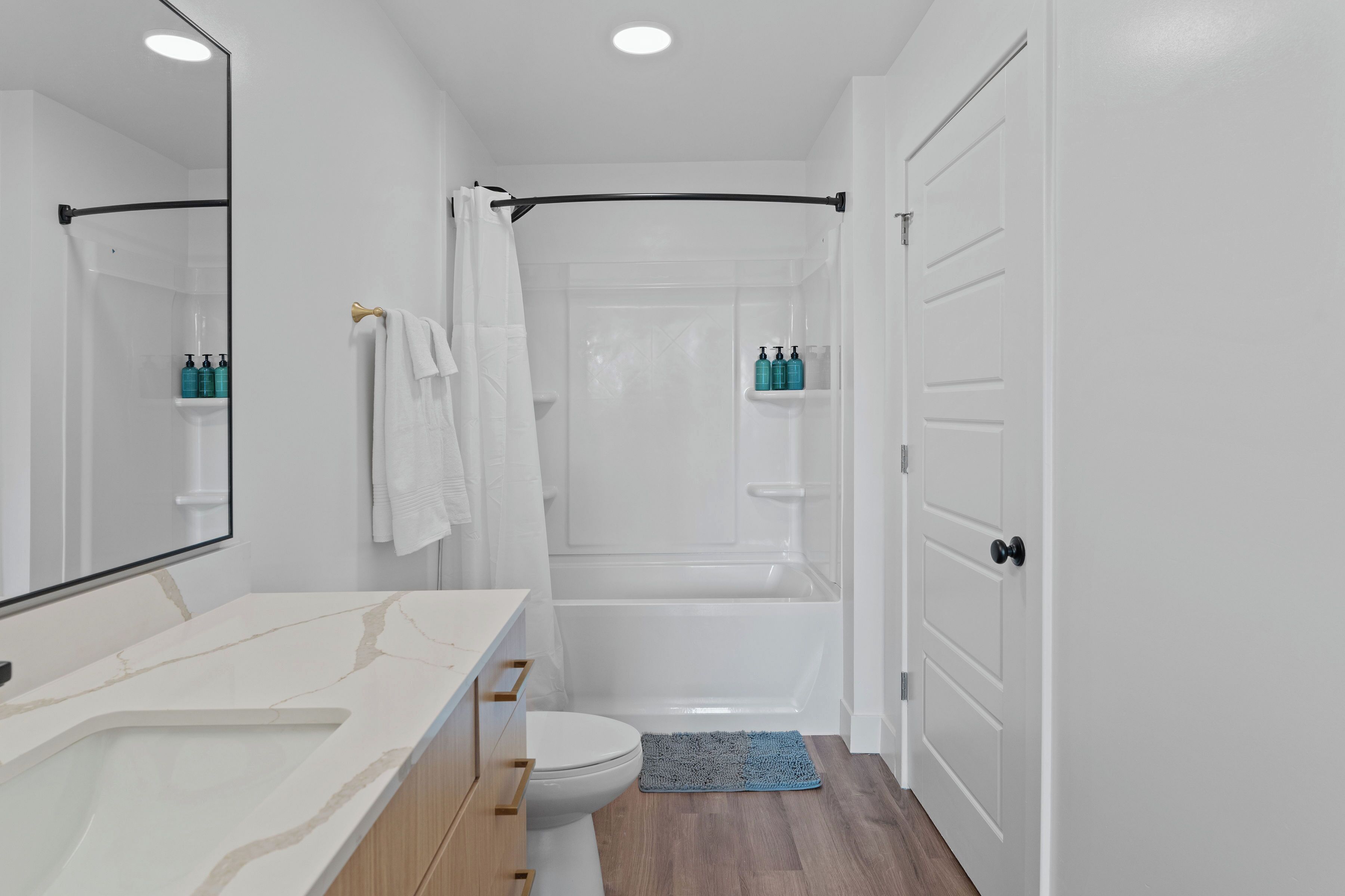 A modern bathroom with a white sink, toilet, and bathtub.