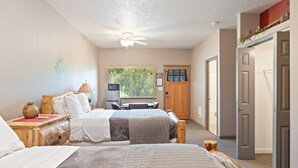A hotel room with two beds, a desk, a chair, a television, and a door. - SouthFork Lodge (Lowman)