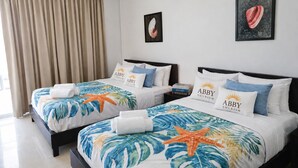 A hotel room with two beds, each with a tropical-themed bedspread, matching pillows, and a starfish decoration. - Blue Escape Suite (rio hato)