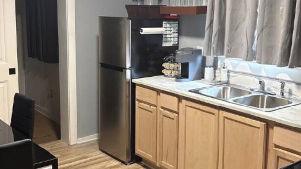 A compact kitchen with a refrigerator, a coffee maker, and a sink. - Cozy and fully furnished (Savannah)