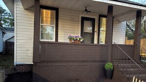 A house with a covered porch, a brick foundation, and a wooden fence. - Cozy and fully furnished (Savannah)